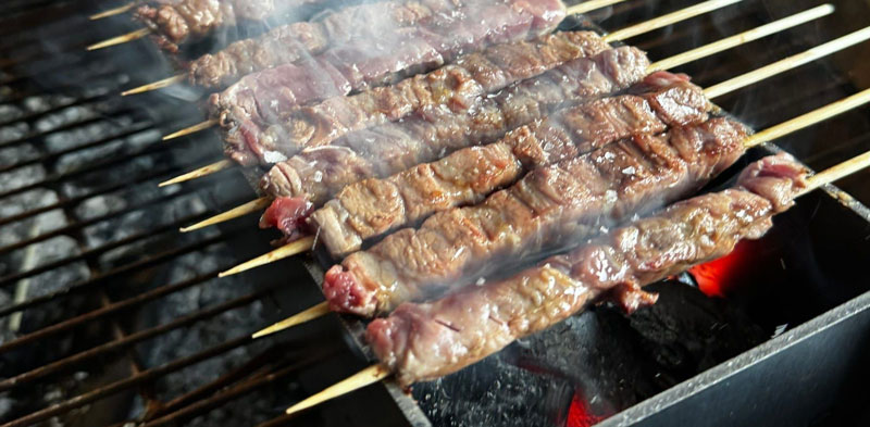 Arrosticini cooking over charcoal